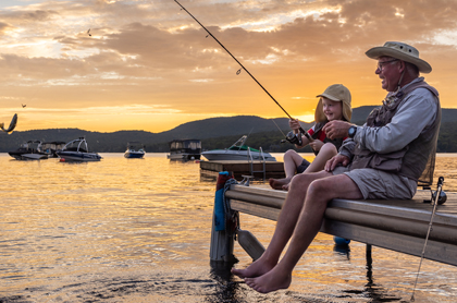 grandad and kid fishing in a sunset